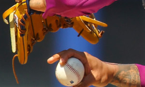 An MLB pitchers winds up to throw the ball